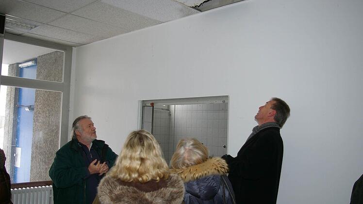 Klaus Christof und Siegfried Müller betrachten ein Loch in der Decke der Schule.