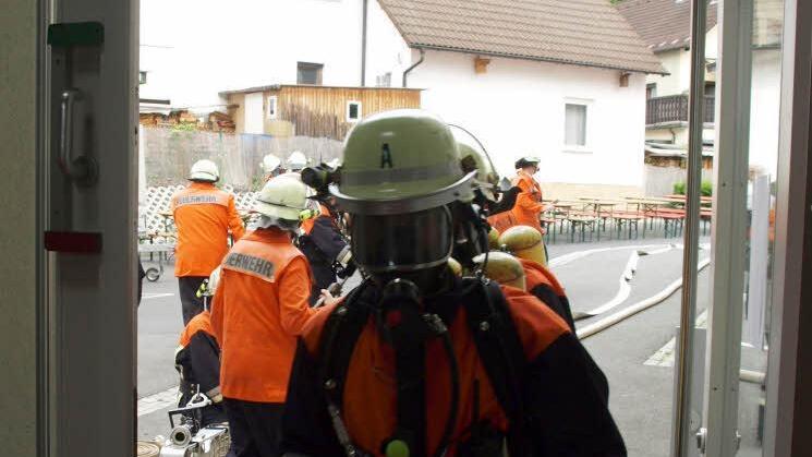 Der erste Atemschutztrupp der Feuerwehr Wallenfels beim Betreten des Gebäudes durch die hintere Tür