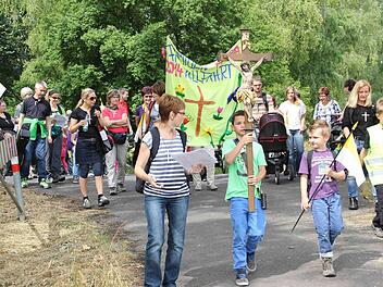 Mit Kreuz und einem selbst gestalteten Transparent zogen die Kinder des Kindergartens Aura aus, um in einer Famlienwallfahrt zum Steinthal zu laufen. Foto: privat