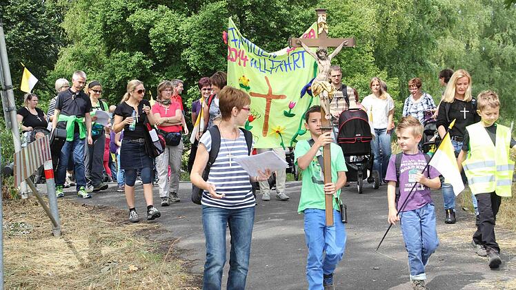 Mit Kreuz und einem selbst gestalteten Transparent zogen die Kinder des Kindergartens Aura aus, um in einer Famlienwallfahrt zum Steinthal zu laufen. Foto: privat