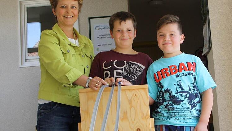 Die Kugelbahn in der Grundschule Wartmannsroth ist zwar eigentlich ein physikalisches Experiment, könnte aber auch symbolisch für das Konzept der Schule stehen: Wie auf den drei Bahnen können Kinder wie Erik (Mitte) und Laurin (rechts) die Eingangsstufe in ein, zwei oder drei Jahren durchlaufen. Schulleiterin Monika Hügel (links) hat die Einführung der Flexiblen Grundschule 2010 begleitet. Foto: Ralf Ruppert