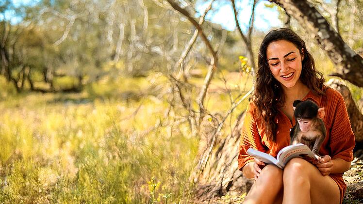 Michi zeigt sich hier im Jahr 2022 mit dem acht Wochen alten Pavianbaby Bodhi, dessen Mama leider von Wildhunden get&ouml;tet wurde.
