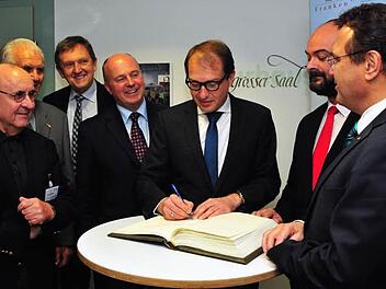 Bundesverkehrsminister Alexander Dobrindt (Dritter von rechts) hat sich beim CSU-Bezirksparteitag in das goldene Buch von Bischofsgrün eingetragen. Über die Schulter blickten ihm dabei (von links) Manfred Thümmler, Simon Nüssel, Landrat Hermann Hübner, Hartmut Koschyk sowie (von rechts) Hans-Peter Friedrich und Bischofsgrüns dritter Bürgermeister Jens Stenglein. Foto: Stephan Herbert Fuchs