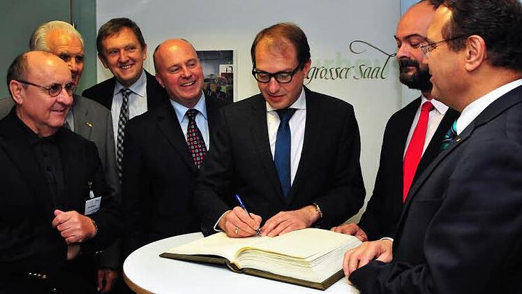 Bundesverkehrsminister Alexander Dobrindt (Dritter von rechts) hat sich beim CSU-Bezirksparteitag in das goldene Buch von Bischofsgrün eingetragen. Über die Schulter blickten ihm dabei (von links) Manfred Thümmler, Simon Nüssel, Landrat Hermann Hübner, Hartmut Koschyk sowie (von rechts) Hans-Peter Friedrich und Bischofsgrüns dritter Bürgermeister Jens Stenglein. Foto: Stephan Herbert Fuchs