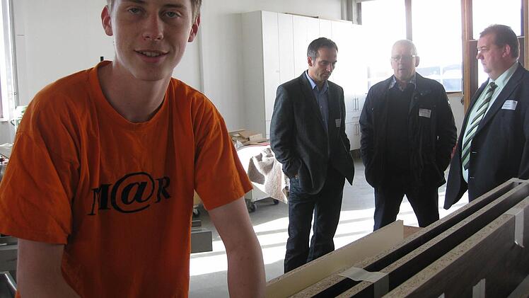 Fabian Knüttel ist im dritten Lehrjahr. Im Hintergrund unterhalten sich beim Tag des Handwerks Wirtschaftsförderer des Landkreises Bad Kissingen, Jürgen Metz, 1. Bürgermeister Oberleichtersbach Walter Müller und der Bürgermeister des Marktes Schondra, Bernold Martin. Foto: Beatrix Lieb