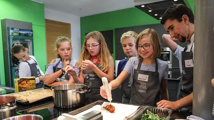 Wann ist das Hühnchen fertig? Magdalena Meisel überprüft mit dem Fleischthermometer die Kerntemperatur des panierten Filets. Paul Schur serviert die selbstgemachten Gnocchi.