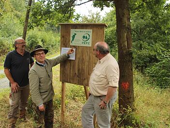 Jagd- und Forsthelfer Helmut Pfromm aus Ziegelerden, Waldeigentümer Heinrich Freiherr von Pölnitz aus Hundshaupten und PEFC-Prüfer Horst Gleißner aus Freising (von links) am "grünen Brett", das am Eingang der Waldungen bei Ziegelerden angebracht ist  Foto: Friedwald Schedel