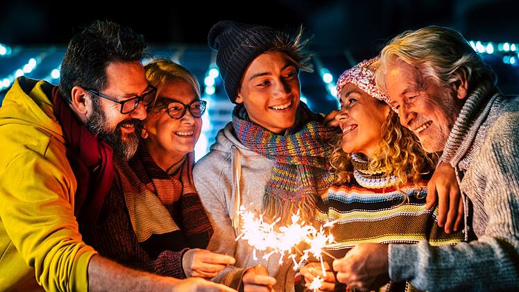 Caucasian happy family enjoy and celebrate by night with fire sparkler all together having fun - christmas and new year eve celebration for group of cheerful people mixed ages and generations Glückliche kaukasische Familie genießt und feiert gemeinsam bei Nacht mit Feuerwerkskörpern und hat viel Spaß – Weihnachts- und Silvesterfeier für eine Gruppe fröhlicher Menschen unterschiedlichen Alters und verschiedener Generationen.