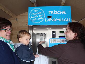 Angelika Brandt hält den kleinen Luke (links), während dessen Mutter Tanja Pfeiffer frische Milch zapft. Foto: Andreas Dorsch