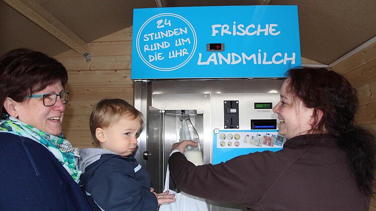 Angelika Brandt hält den kleinen Luke (links), während dessen Mutter Tanja Pfeiffer frische Milch zapft. Foto: Andreas Dorsch