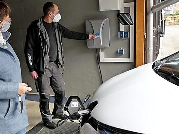 Frank Schubert hat die Anzeige an der Wallbox auf "Grün" gestellt. Ingrid Flieger kann ihr Elektroauto jetzt an der ersten E-Tankstelle in Trebgast laden.  Foto: Dieter Hübner