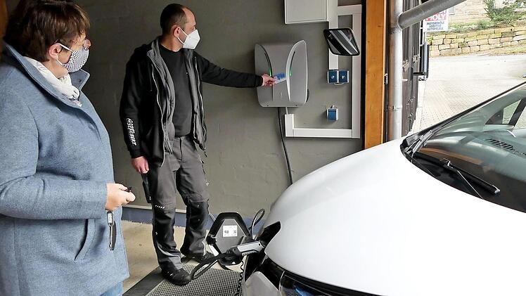 Frank Schubert hat die Anzeige an der Wallbox auf "Grün" gestellt. Ingrid Flieger kann ihr Elektroauto jetzt an der ersten E-Tankstelle in Trebgast laden.  Foto: Dieter Hübner