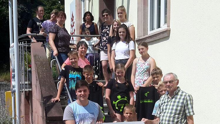 Robin Schneider (vorn links) als Vertreter der Spendergruppe überreichte im Beisein von Gönnern und Beschenkten den symbolischen Scheck an den stellvertretenden Vorsitzenden des Fördervereins Maria Bildhausen, Hans Hohn (rechts). Rolf Pralle