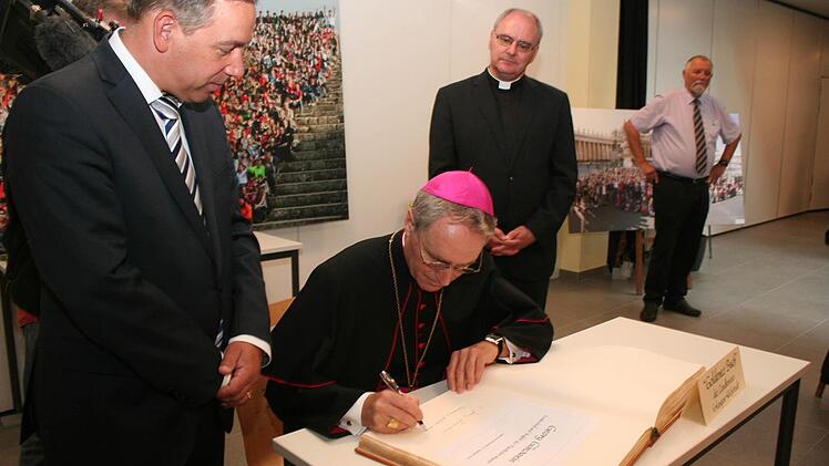 Erzbischof Gänswein trägt sich in das Goldene Buch des Landkreises ein. Im Bild links Landrat Alexander Tritthart, rechts Dekan Kilian Kemmer und der stellvertretende Schulleiter Ulrich Günther Foto: Evi Seeger