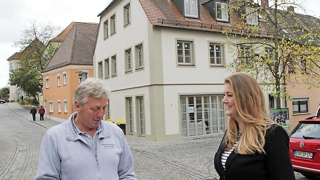 Clarissa Karnatz (rechts) ist mit ihrer Sprachschule in das sanierte Anwesen am Schlossberg (im Hintergrund) gezogen, das urspr&uuml;nglich ein Caf&eacute; werden sollten. Mit dem Lonnerstadter Bodenleger Rainer Haberkamm bespricht sie die letzten Arbeiten.  Foto: Andreas Dorsch