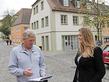 Clarissa Karnatz (rechts) ist mit ihrer Sprachschule in das sanierte Anwesen am Schlossberg (im Hintergrund) gezogen, das ursprünglich ein Café werden sollten. Mit dem Lonnerstadter Bodenleger Rainer Haberkamm bespricht sie die letzten Arbeiten.  Foto: Andreas Dorsch
