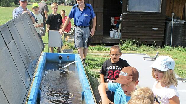 Dass sich Forellen mit dem Kescher aus dem Bassin leicht fangen lassen, erlebten die Buben und M&auml;dchen beim Ferienprogramm des Fischclubs auf der Teichanlage von Wolfgang Maisel. Foto: Bruno Prei&szlig;inger