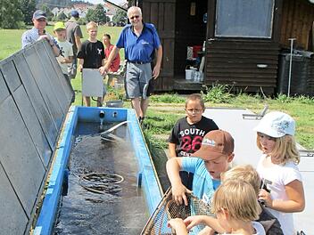 Dass sich Forellen mit dem Kescher aus dem Bassin leicht fangen lassen, erlebten die Buben und M&auml;dchen beim Ferienprogramm des Fischclubs auf der Teichanlage von Wolfgang Maisel. Foto: Bruno Prei&szlig;inger