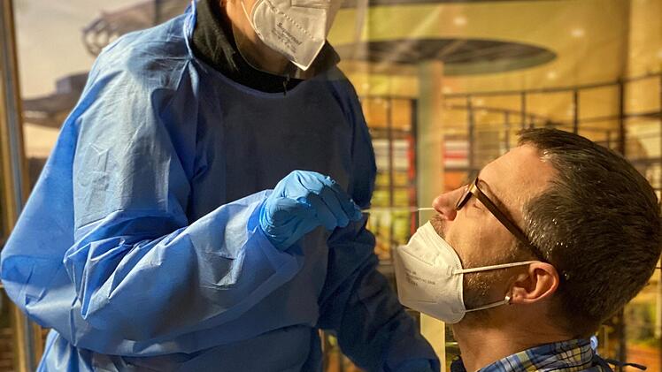Christiane Bruns von der DLRG macht einen Corona-Schnelltest für ihren Kollegen Frank Wehner bevor die Schicht der beiden Ehrenamtlichen beginnt.