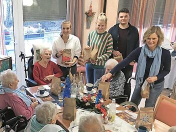 Laura Kraus (v.l.), Tamara Kaiser, Nick Sandner und Ingrid Schoyerer teilen die Tüten mit den selbstgebackenen Plätzchen aus. Sehr zur Freude der Senioren im Zentrum für Betreuung und Pflege Curanum.  Foto: Busch