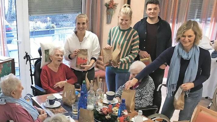 Laura Kraus (v.l.), Tamara Kaiser, Nick Sandner und Ingrid Schoyerer teilen die Tüten mit den selbstgebackenen Plätzchen aus. Sehr zur Freude der Senioren im Zentrum für Betreuung und Pflege Curanum.  Foto: Busch
