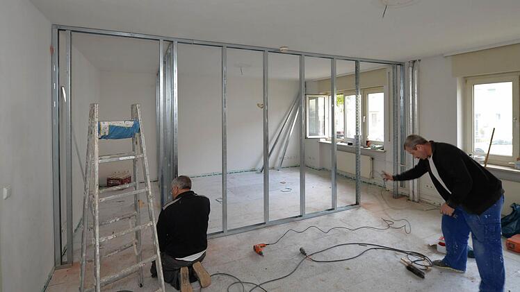 Handwerker bauen die Abtrennung für ein neues Zimmer auf.