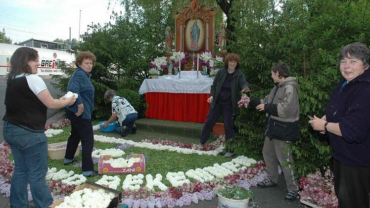 Besonders der Blumenteppich aus Hunderten von bunten Blüten erfordert akribische Arbeit beim Altaraufbau.