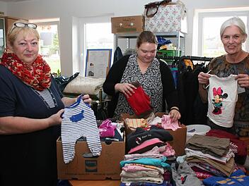 Frauen vom Helferkreis "Helfende Hände" beim Sortieren von Baby- und Kinderkleidung nach Größen Foto: Evi Seeger