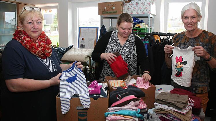 Frauen vom Helferkreis "Helfende Hände" beim Sortieren von Baby- und Kinderkleidung nach Größen Foto: Evi Seeger