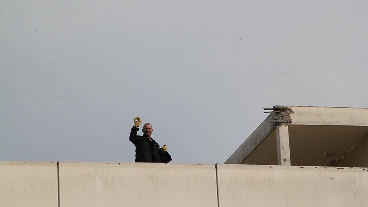 Ein Bauarbeiter winkt aus der Ferne. Foto: Ulrike Müller