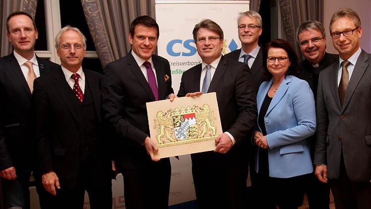 CSU-Kreisvorsitzender und MdL Steffen Vogel überreichte dem Minister das Bayerische Wappen, das von Hermann Schnös aus Westheim gefertigt worden war. Von links Bürgermeister Michael Ziegler, Ltd. Oberstaatsanwalt Erik Ohlenschlager, MdL Steffen Vogel, Justizminister Dr. Winfried Bausback, die Caritasdirektoren Dr. Wolfgang Kues und Pia Theresia Frank, Domkapitular Clemens Bieber sowie stv. IHK-Hauptgeschäftsführer Jürgen Bode.
