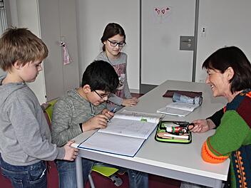 Erika Freibott (rechts) ist schon lange dabei. Sie  sitzt  mit (von links) Joshua, Hasan und Ella in Teamarbeit bei den Hausaufgaben.