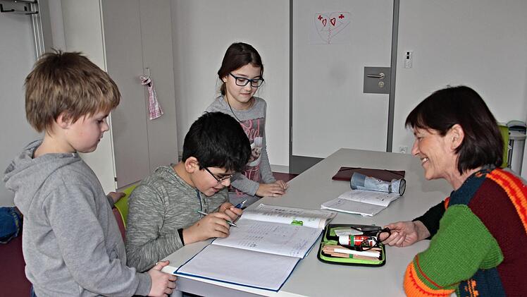 Erika Freibott (rechts) ist schon lange dabei. Sie  sitzt  mit (von links) Joshua, Hasan und Ella in Teamarbeit bei den Hausaufgaben.