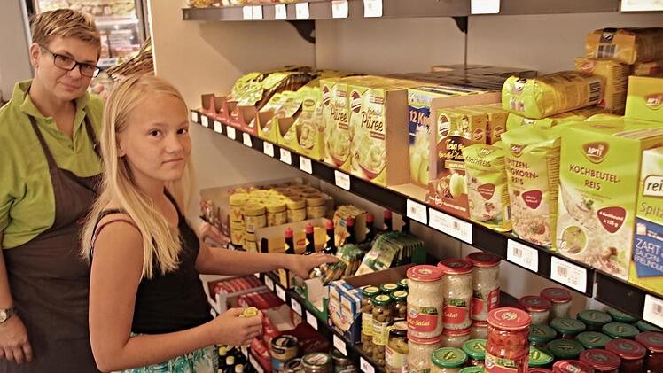 Carmen Bernard (links), Mitarbeiterin im Dorfladen in Burgpreppach, zeigt Luisa Hetzel das es wichtig ist die Waren im Regal richtig zu postieren. Helmut Will