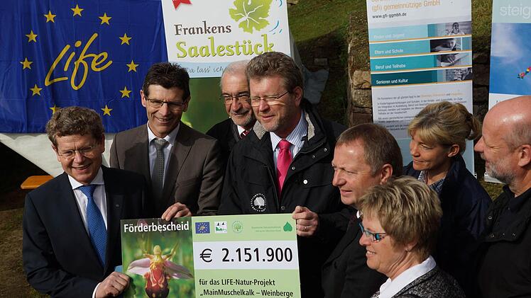 Marcel Huber (Mitte) überreicht den Förderbescheid