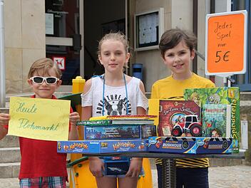 David (von links), Linda und William haben schon mal probeweise einen Stand für den Kinderflohmarkt aufgebaut. Foto: Ulrike Müller