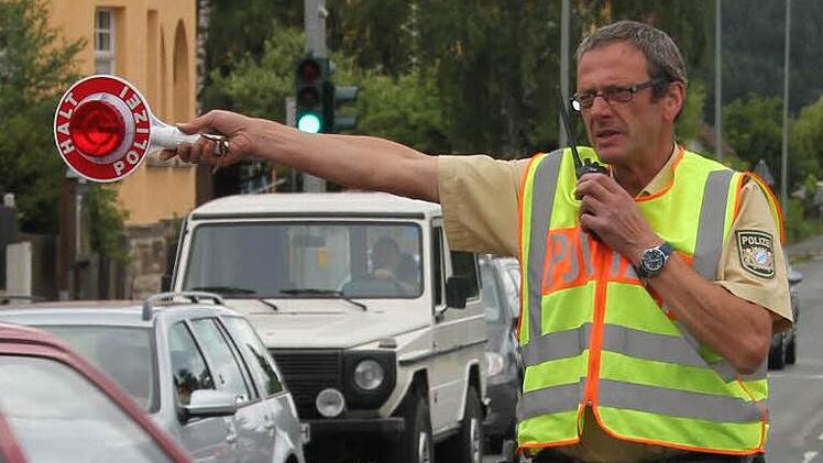 Thomas Graf zieht einen Handysünder aus dem fließenden Verkehr auf der Bundesstraße bei Gundelsdorf raus. Per Sprechfunk hat er eine Beschreibung des Wagens erhalten, so dass er zielsicher rauswinken kann. Foto: Friedwald Schedel