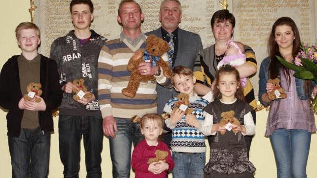 Familienfoto mit Bürgermeister: Wladie, Johann, Vater Vladimir Korn, Amelia, Julian, Mutter Dina mit Arina, Ariane und Alexandra (von links) freuen sich über die Ehrenpatenschaft von Bundespräsidenten Joachim Gauck, die ihnen von Bürgermeister Norbert Tessmer (Mitte) verliehen wurde. Foto: Katja Nauer