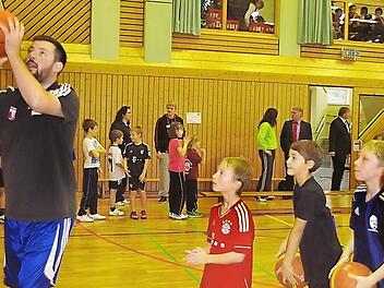 Coach Simon (links) zeigt den Kindern der Lucas-Cranach-Schule die richtige Wurftechnik. Foto: Heike Schülein