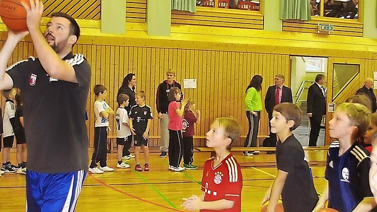 Coach Simon (links) zeigt den Kindern der Lucas-Cranach-Schule die richtige Wurftechnik. Foto: Heike Schülein