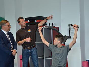 Vorführung an einem Krafttrainingsgerät im neuen Fitnessraum an der Realschule: Der Schüler Tim Maier trainiert, sein Lehrer Felix Pitroff erklärt und Landrat Alexander Tritthart lauscht.  Fotos: Bernhard Panzer