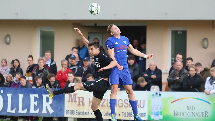 Der Sander Doppeltorsch&uuml;tze Adrian Reith (links) ist zum Kopfballduell mit dem Erlanger Jan Sperber hochgestiegen. Foto: Ralf Naumann