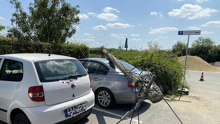 Sattelauflieger beschädigt Telefonleitung: Mast kippt auf geparkte Fahrzeuge