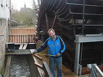 Helmut Vorndran vor dem kürzlich installierten Mühlrad, das mit Computertechnik gesteuert wird und Strom erzeugt. Foto: Matthias Einwag