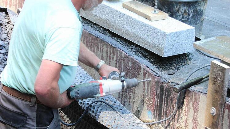 Ein Arbeiter bohrt die Befestigung für die Schalung.  Foto: Friedwald Schedel