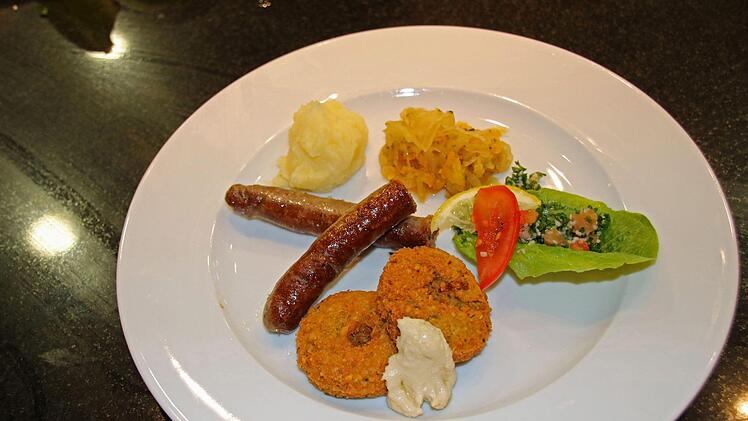 Rindsbratwurst mit Sauerkraut und Kartoffelpüree, Falafel mit Humus und Tabouleh: Das steht auf dem Speisezettel wenn Menschen aus Syrien und Deutschland miteinander kochen. Foto: Katrin Geyer