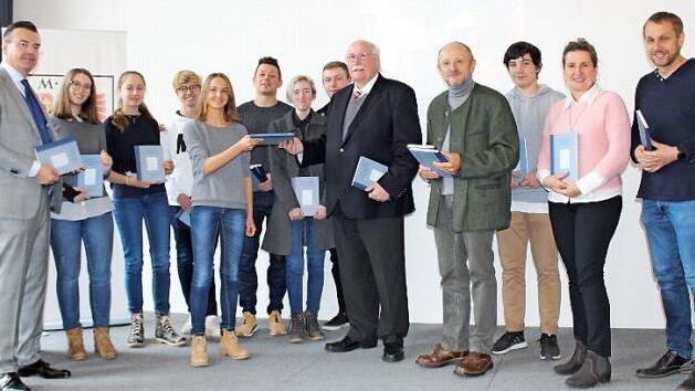 Vorsitzender Regierungspräsident i.R. Wilhelm Wenning (Fünfter von rechts) und Schriftführer Bruno Hager (Vierter von rechts) bei der Übergabe des Tournon-Reprints an die MGF-Oberstufenkurse im Fach Geschichte in der Aula; links Schulleiter Horst Pfadenhauer Foto: privat