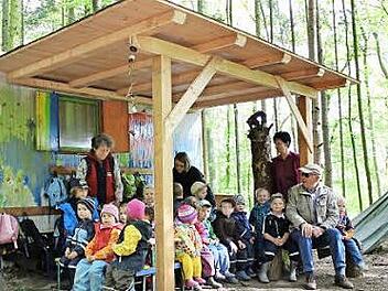 Martin Plettl aus Kasendorf (rechts) schaut gerne nochmal im Waldkindergarten vorbei, um zu sehen, ob sich das neue Dach bewährt. Jakob Lauter bach (sitzend neben Plettl) und sein Vater Bernd haben ebenfalls mitgebaut. Foto: Katharina Müller-Sanke