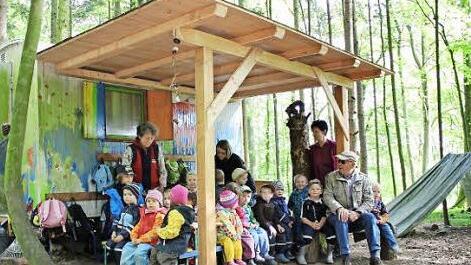 Martin Plettl aus Kasendorf (rechts) schaut gerne nochmal im Waldkindergarten vorbei, um zu sehen, ob sich das neue Dach bewährt. Jakob Lauter bach (sitzend neben Plettl) und sein Vater Bernd haben ebenfalls mitgebaut. Foto: Katharina Müller-Sanke