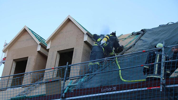 Bai Bauarbeiten an einem Haus in der Münnerstädter Hennebergstraße hat eine Gaube Feuer gefangen. Die Feuerwehrmänner mussten das Dach teilweise öffnen, um an den Brandherd zu gelangen.  Foto: Thomas Malz